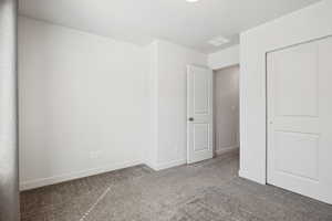 Unfurnished bedroom with carpet and a closet