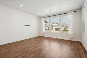 Empty room featuring dark wood-style floors and a textured ceiling