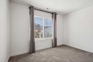 Unfurnished room featuring carpet and baseboards
