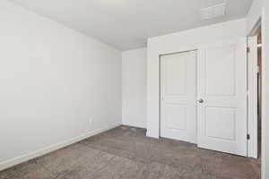 Unfurnished bedroom featuring carpet and a closet