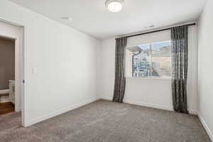 Unfurnished room featuring carpet floors and a textured ceiling