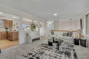 Living room with ornamental molding, light carpet, and recessed lighting