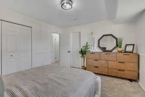 Bedroom featuring light colored carpet and a closet