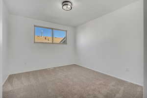 Carpeted empty room with baseboards