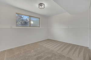 Carpeted empty room featuring baseboards