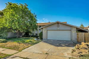 View of front facade featuring brick siding, concrete driveway, and an attached garage