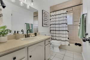 Full bathroom with tile patterned floors, vanity, and shower / bath combo