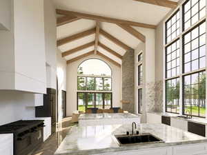 Kitchen featuring high vaulted ceiling, a center island, beamed ceiling, double oven range, and white cabinets