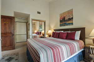 Carpeted bedroom with a high ceiling