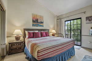Carpeted bedroom featuring lofted ceiling and access to outside