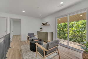 Sitting room with light wood-style flooring and recessed lighting