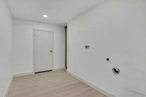 Washroom featuring hookup for an electric dryer, light wood-type flooring, hookup for a washing machine, and recessed lighting