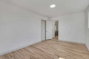 Empty room with baseboards and light wood-style flooring