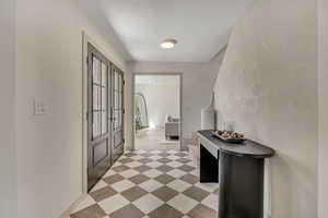 Foyer with light floors and baseboards