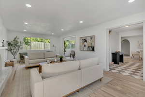Living room featuring light wood-style floors, recessed lighting, and arched walkways