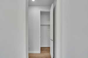 Corridor featuring baseboards and light wood finished floors
