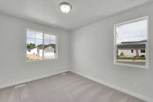 Empty room featuring carpet flooring and baseboards