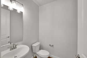 Half bath featuring toilet and a sink