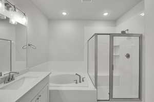 Bathroom featuring vanity, a garden tub, a stall shower, and recessed lighting