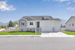 View of front facade featuring a mountain view, stone siding, concrete driveway, a garage, and board and batten siding