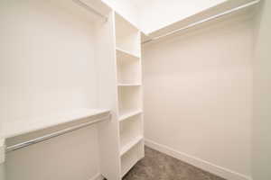 Walk in closet featuring dark carpet