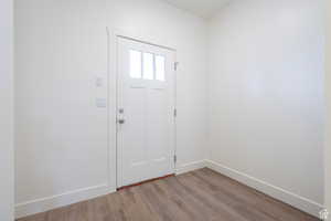 Foyer featuring light wood-style flooring and baseboards