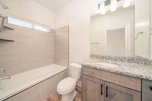 Bathroom featuring vanity, shower / bathtub combination, and wood finished floors
