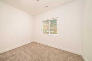 Spare room with light carpet and baseboards