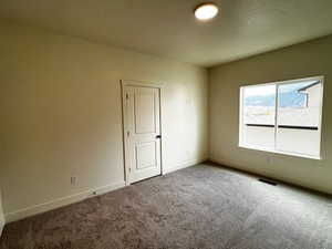 Carpeted empty room featuring baseboards