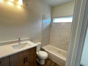 Bathroom featuring vanity, dark wood-style flooring, and shower / tub combination