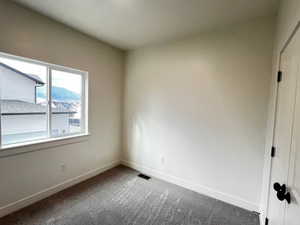 Empty room featuring carpet floors and a mountain view