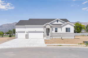 View of front of house with a mountain view, brick siding, driveway, a garage, and a shingled roof