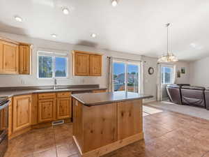 Kitchen featuring open floor plan, dark countertops, light tile patterned floors, and recessed lighting