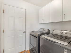Laundry area with cabinet space and washer and clothes dryer