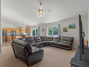 Living room with lofted ceiling, a chandelier, light colored carpet, a ceiling fan, and recessed lighting