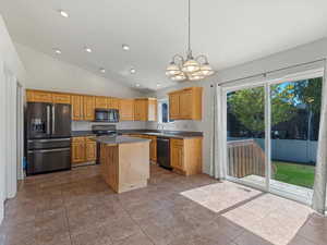 Kitchen featuring appliances with stainless steel finishes, lofted ceiling, a chandelier, recessed lighting, and a kitchen island