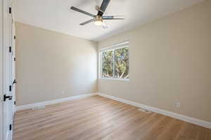 Empty room with light wood finished floors and ceiling fan