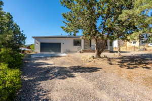 View of front of property with driveway, a garage, and stucco siding
