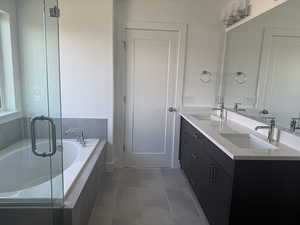 Bathroom with a garden tub, double vanity, a stall shower, and tile patterned floors