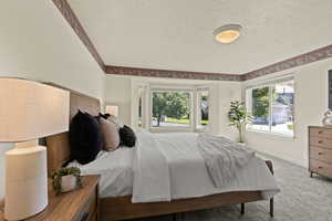 Bedroom with a textured ceiling and carpet