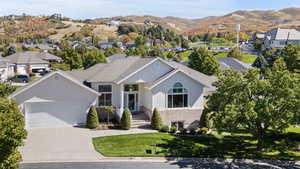 Ranch-style house with stucco siding, driveway, an attached garage, and a mountain view