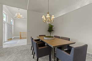 Dining area featuring a chandelier, light carpet, and ornamental molding