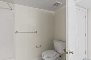 Bathroom featuring a textured ceiling and tile patterned flooring