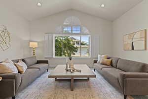 Carpeted living area featuring lofted ceiling and recessed lighting