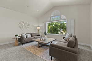 Living area with light colored carpet, high vaulted ceiling, and recessed lighting
