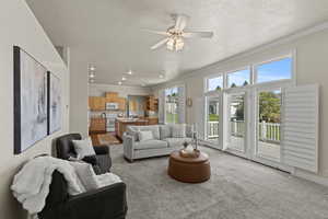 Living area featuring light carpet, ceiling fan, a textured ceiling, recessed lighting, and ornamental molding