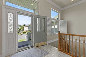 Entrance foyer featuring ornamental molding, light marble finish floors, and recessed lighting
