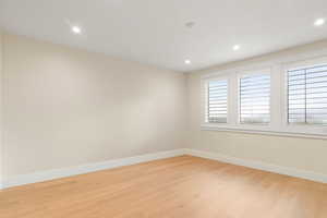 Empty room featuring light wood finished floors and recessed lighting