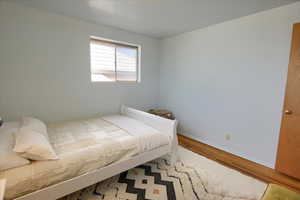 Bedroom with wood finished floors and baseboards