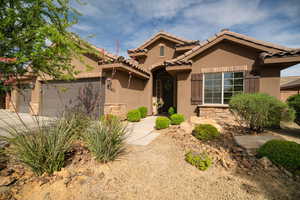 Mediterranean / spanish-style house with stone siding, stucco siding, a garage, a tile roof, and driveway